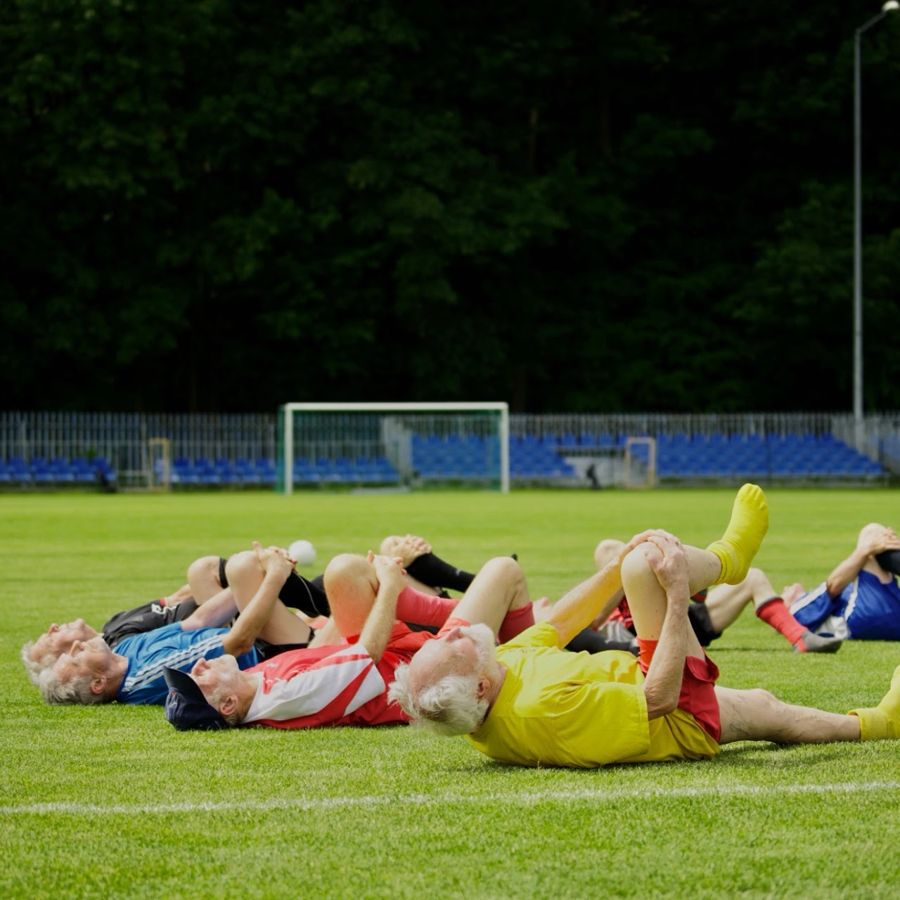 Spieler bei Dehn&uuml;bungen auf dem Rasen